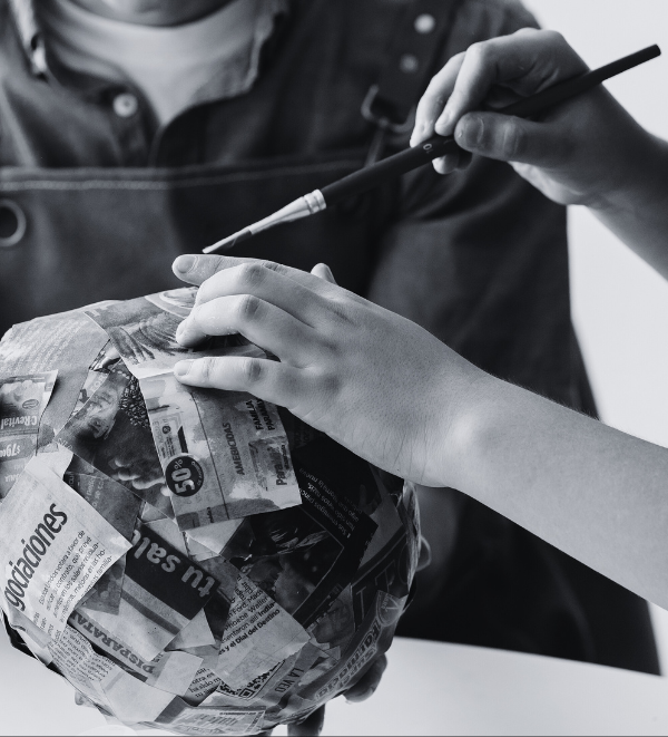 Black and white photo of hands working on a paper mache project Black and white photo of hands working on a paper mache project