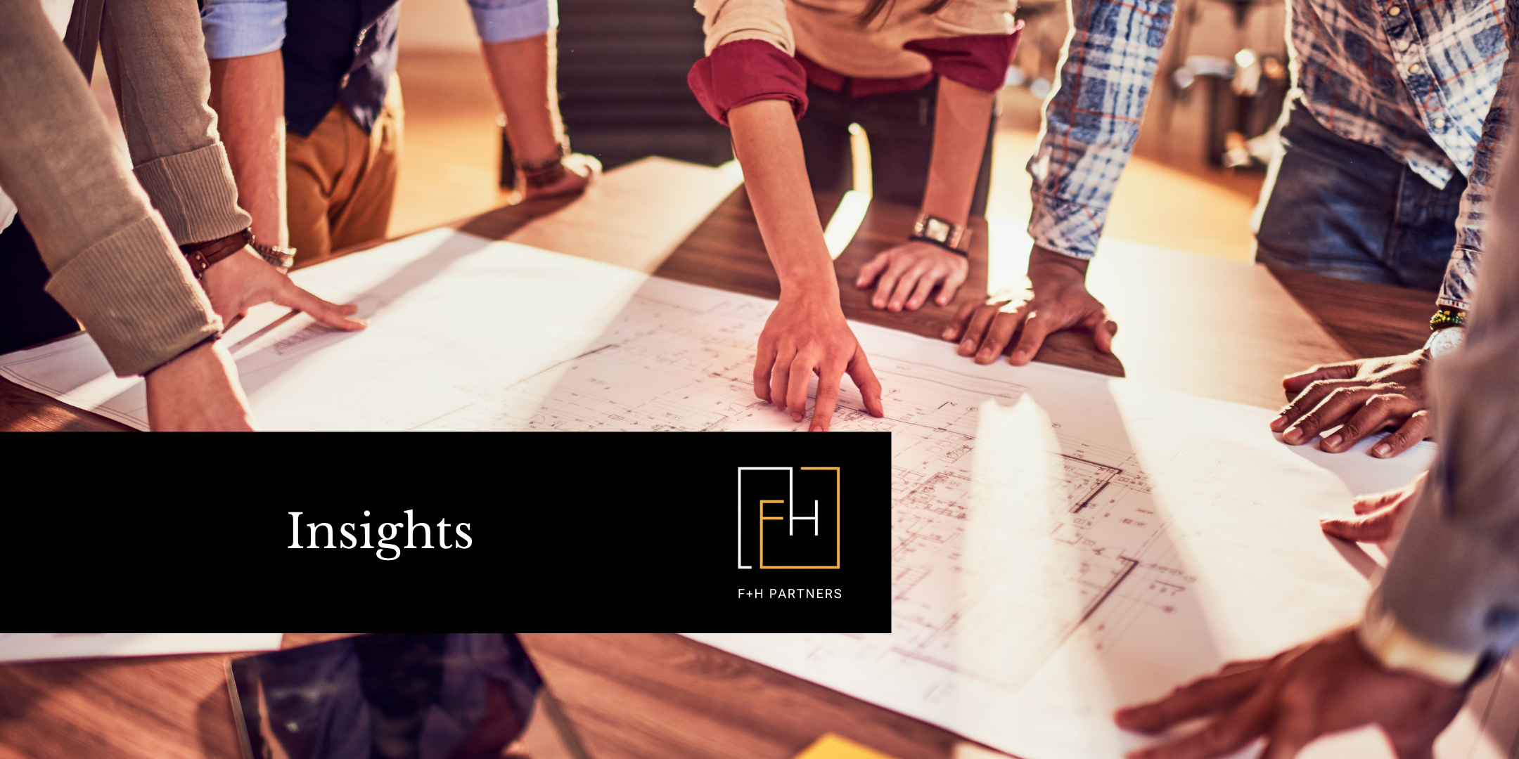 Group of people standing around a table reviewing plans together, symbolizing collaborative planning and strategic preparation for a major fundraising campaign.