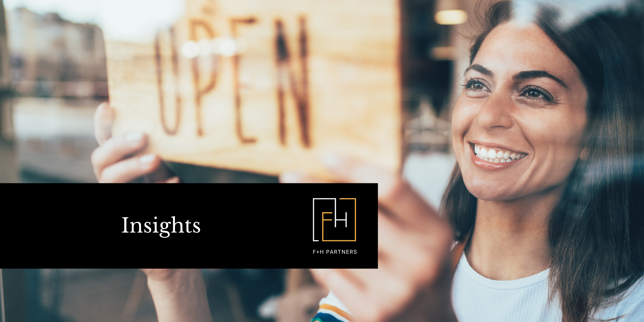 Smiling woman turning an “Open” sign in a window, symbolizing turning vision into action and bringing strategic plans to life through fundraising support.